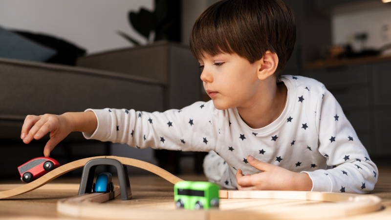 Lapsi leikkii leluautoilla.