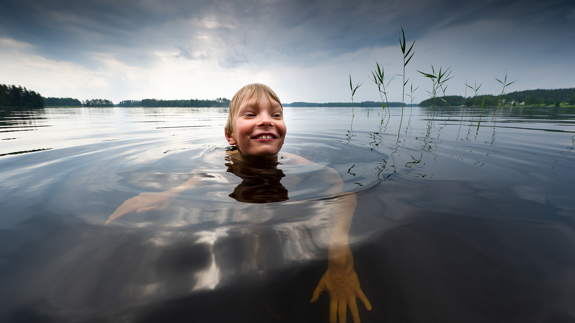 Ett barn simmar i sjön.