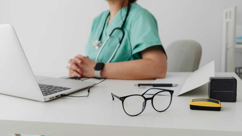 A nurse sitting in front of a computer.