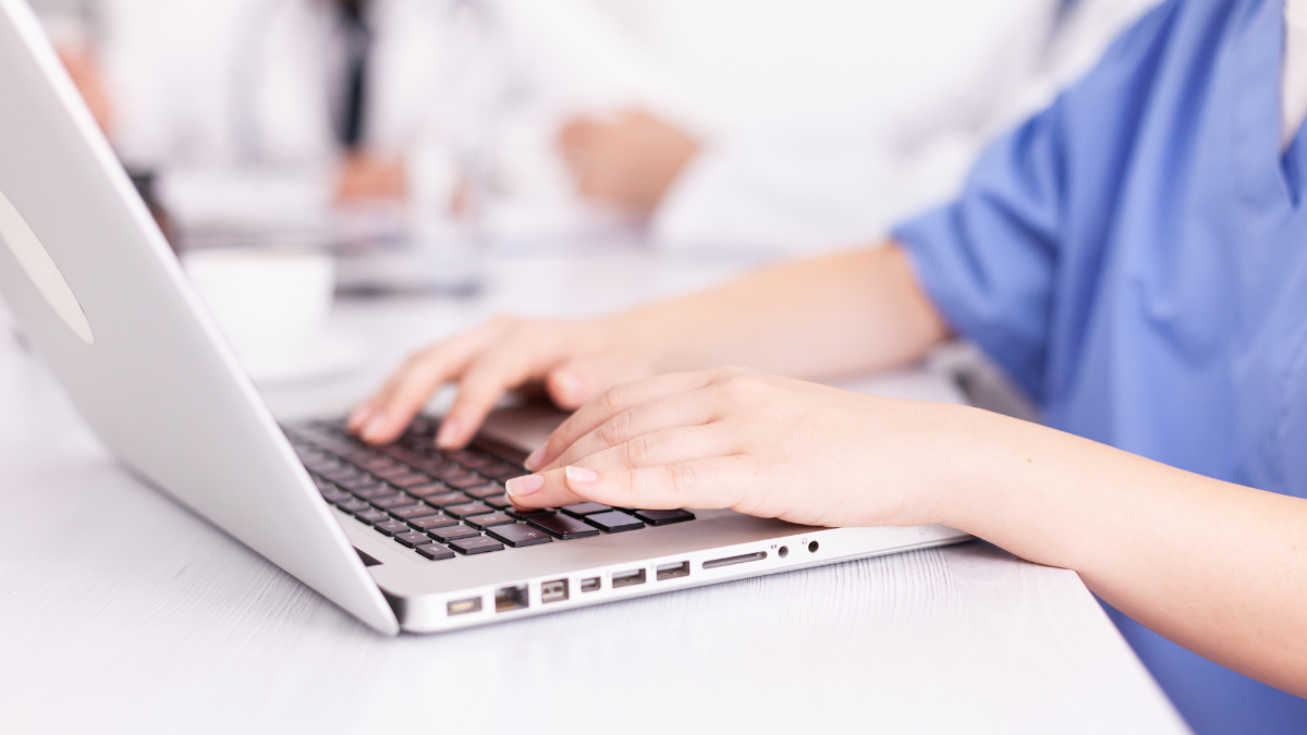 Hoitaja tietokoneella.