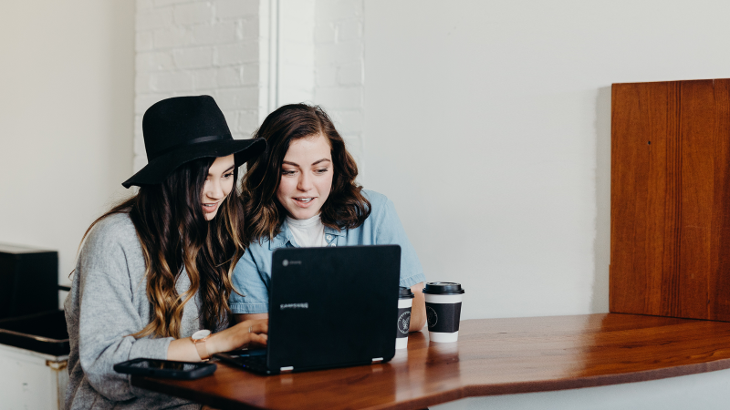 Two persons in front of a laptop.