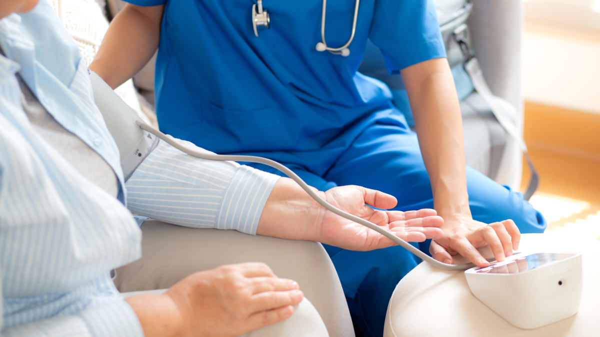 Hoitaja mittaa potilaan verenpainetta.