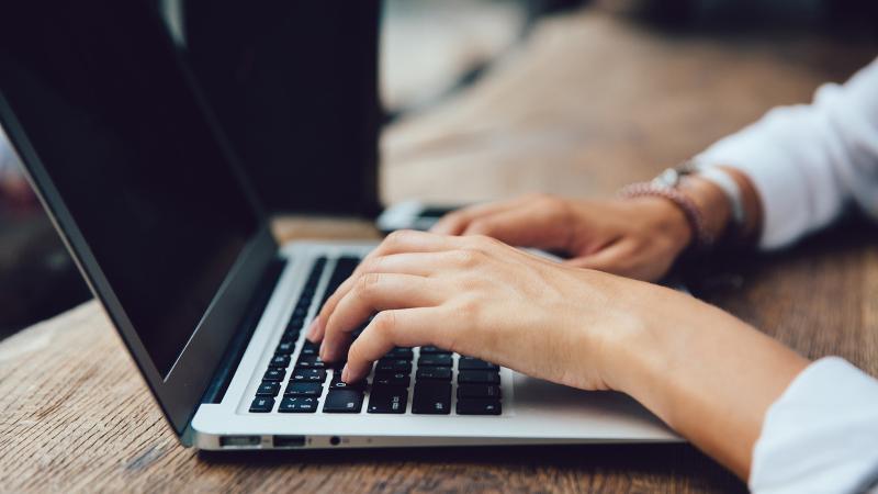 Hands on the laptop's keyboard.